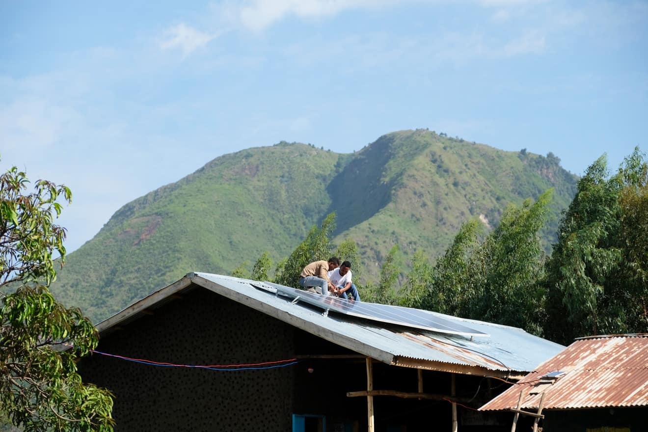 Äthiopische Solartechniker installieren eine Solarzelle auf einem Dach einer Schule während der praktischen Ausbildung.
