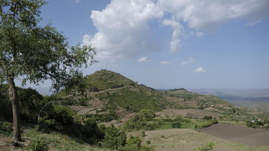 Blick auf die hügelige Landschaft Äthiopiens unter blauem Himmel.