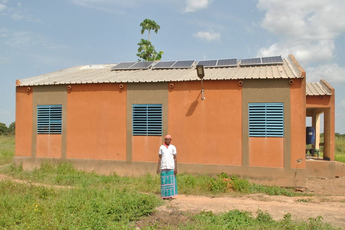Kadi Paré, Krankenpflegerin, vor dem Centre de Santé et de Promotion Sociale im Dorf Tintilou Nord in Burkina Faso mit einer Solaranlage