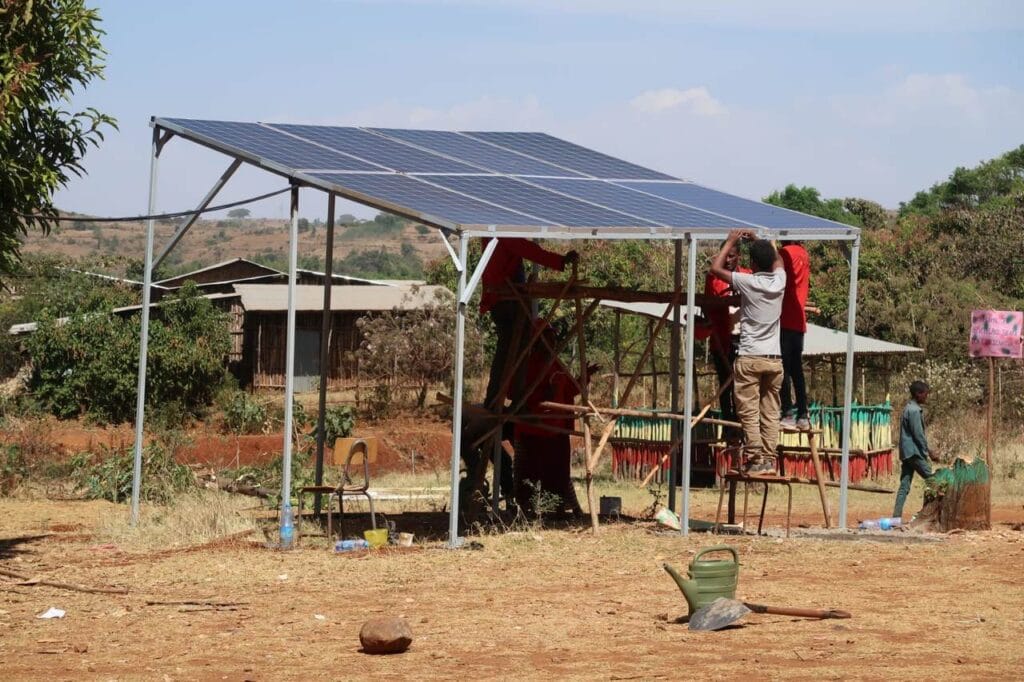 Auszubildende installieren eine Solaranlage, die auf dem Boden steht