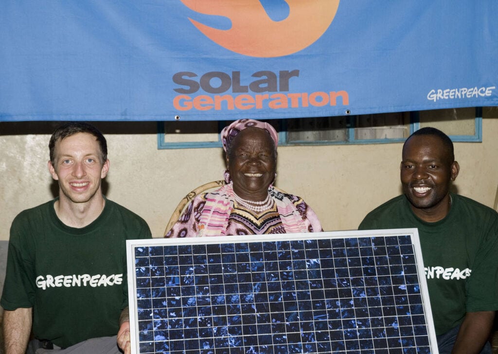 Sarah Obama mit einem Solarpanel und zwei der vier Gründungsmitglieder von Solafrica