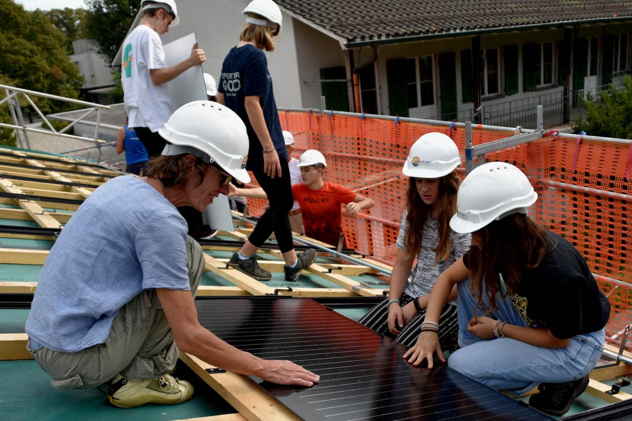 Zwei Schülerinnen der Schule Munzinger installieren mit Lehrerin Vesna Bechstein im Rahmen der Jugendsolar-Projektwoche eine Solaranlage auf dem Schulhausdach Marzili