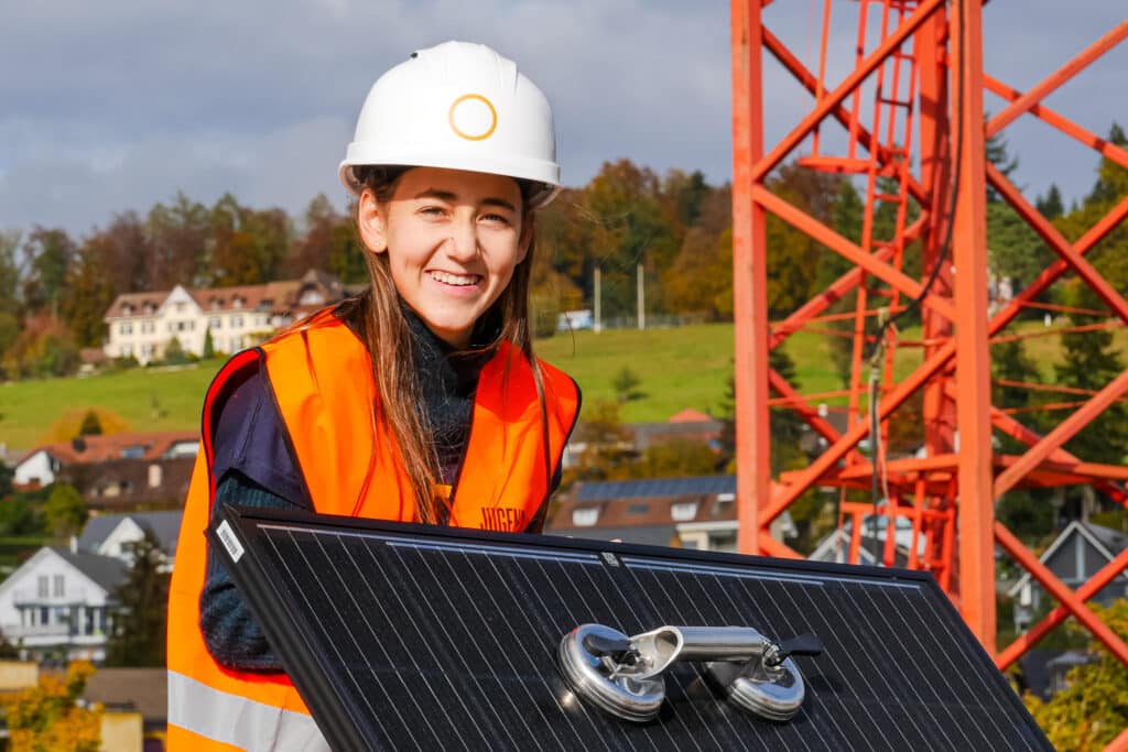 Jugendliche installieren eine Solaranlage in der Schweiz – Solarenergie stärkt Bildung und Zukunftsperspektiven.