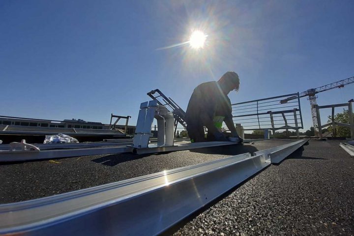 Ein Mann bereitet auf dem Dach die Installation einer Solaranlage vor