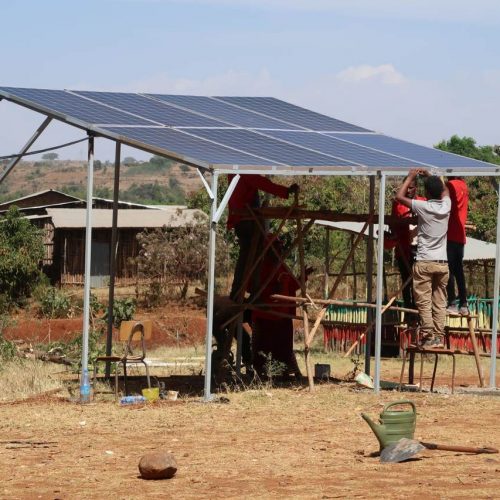 Auszubildende installieren eine Solaranlage, die auf dem Boden steht